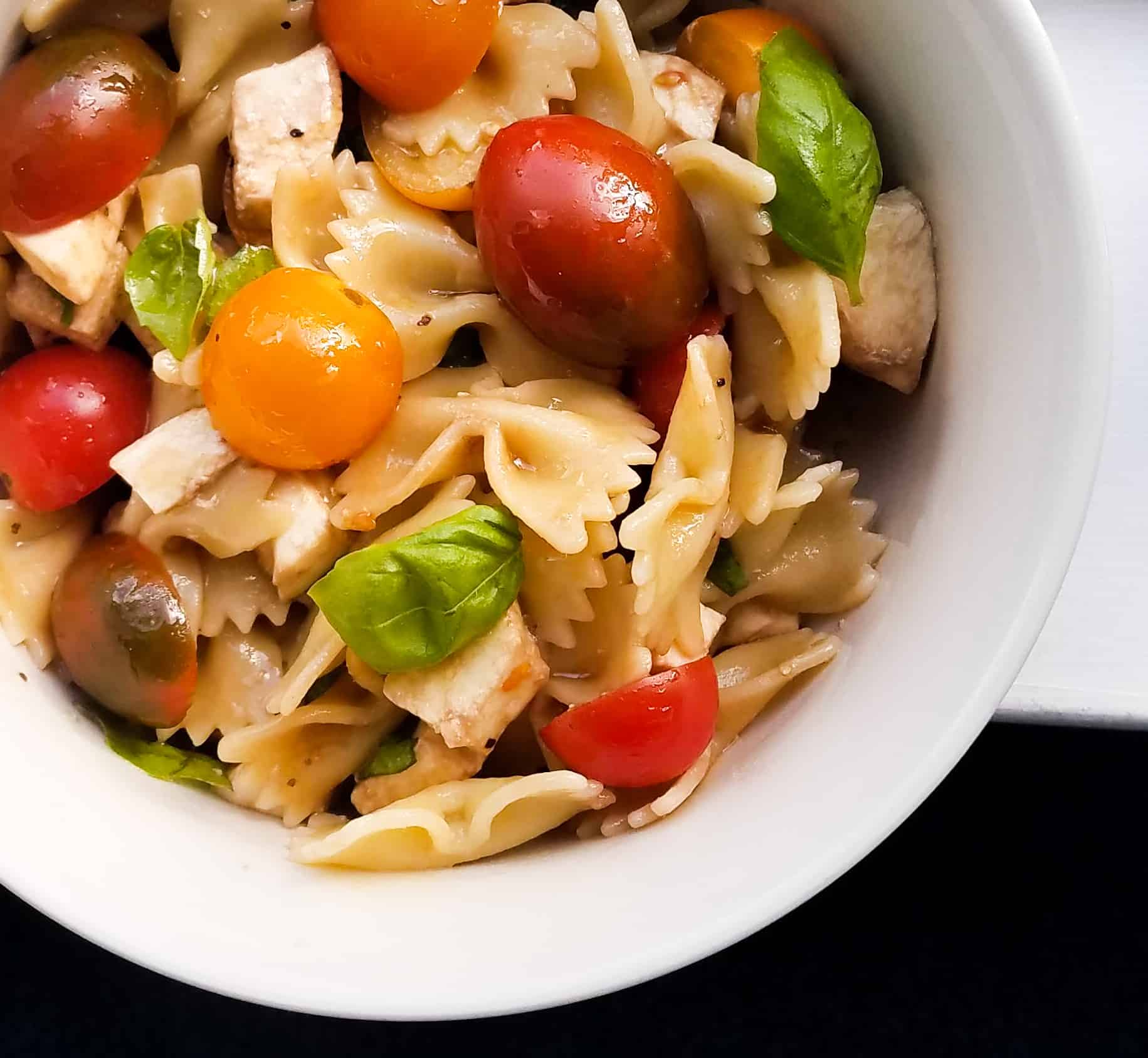 A bowl of caprese pasta salad that showcases Italian flavors.