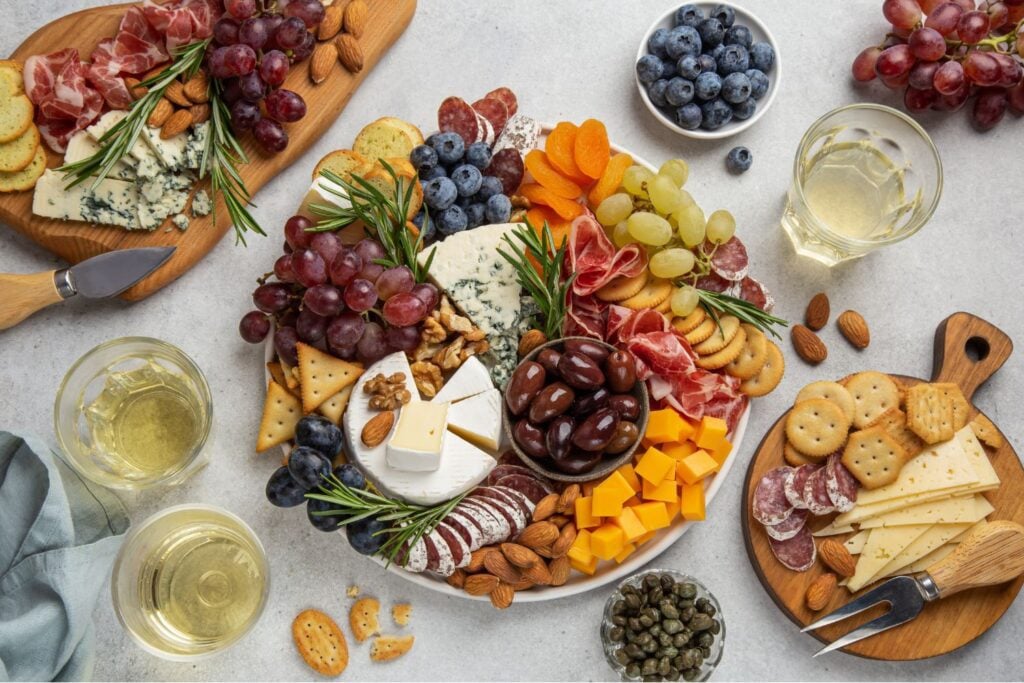A well-organized grazing table featuring cheeses and fruits